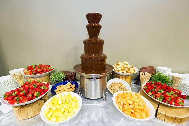 Chocolate fondue fountain with fruit and cake