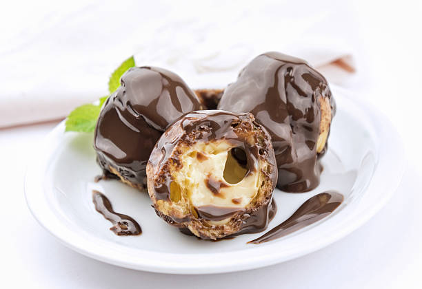 Profiteroles dessert with cream and chocolate glaze on a plate