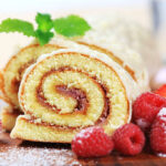 Slices of Swiss roll and fresh raspberries